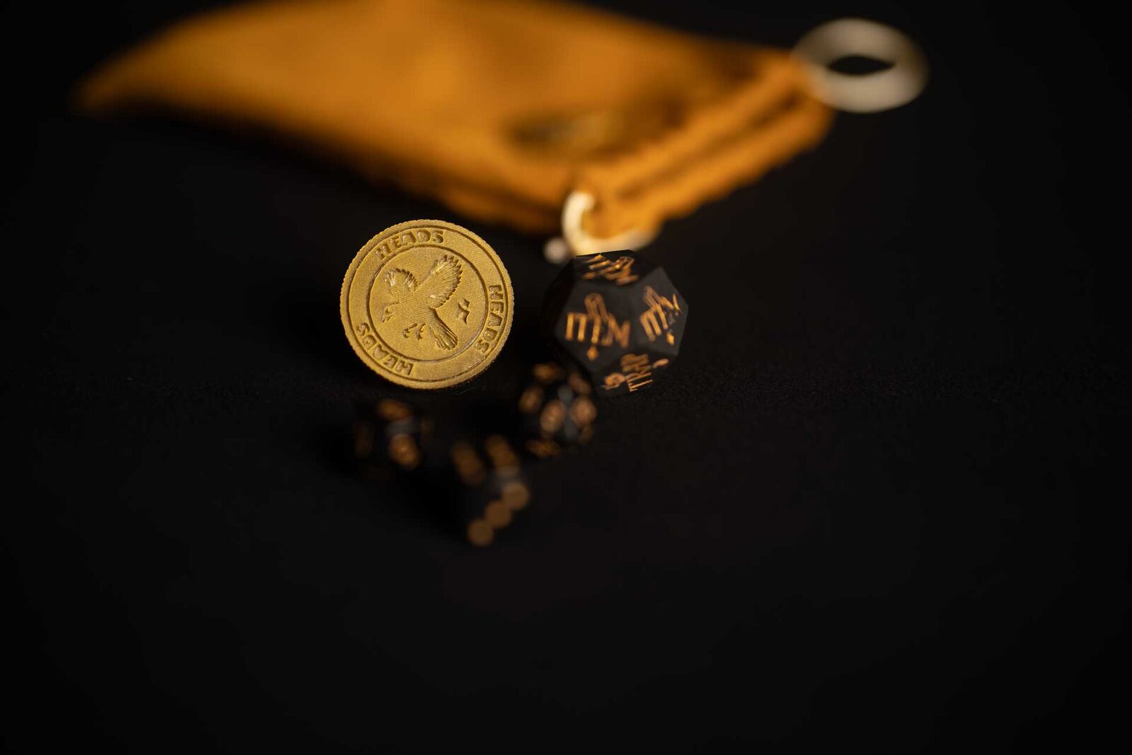 The golden pouch with the Flip the Bird coin and custom resin dice